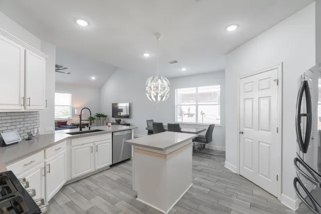 a kitchen with white cabinets and sink