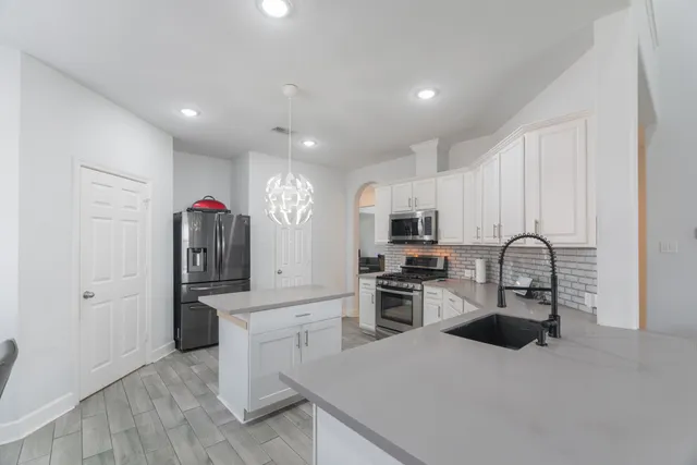 a kitchen with stainless steel appliances granite countertop a refrigerator sink and stove