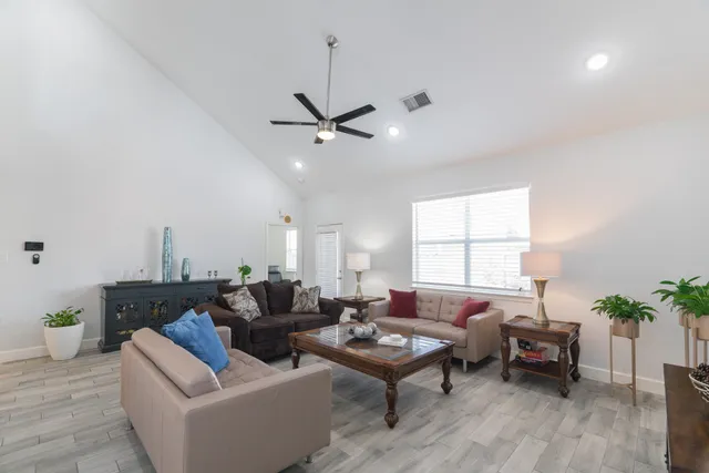a living room with furniture a window and a potted plant