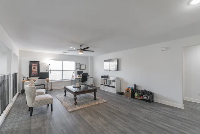 a living room with furniture and a wooden floor