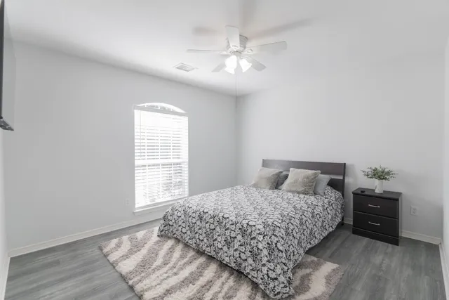 a bedroom with a large bed and a chandelier