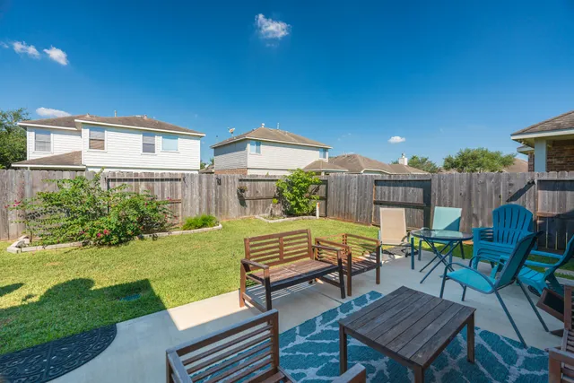a view of a patio with table and chairs and potted plants