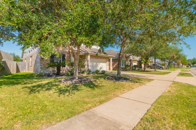 a view of swimming pool with outdoor seating and trees in the background