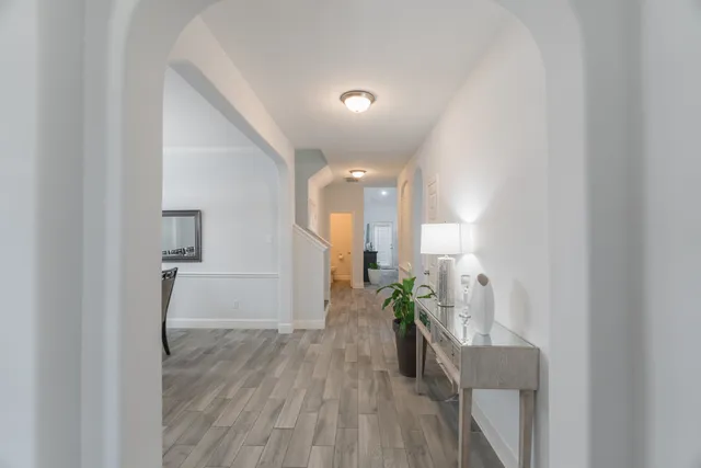 a view of a hallway with wooden floor and a potted plant