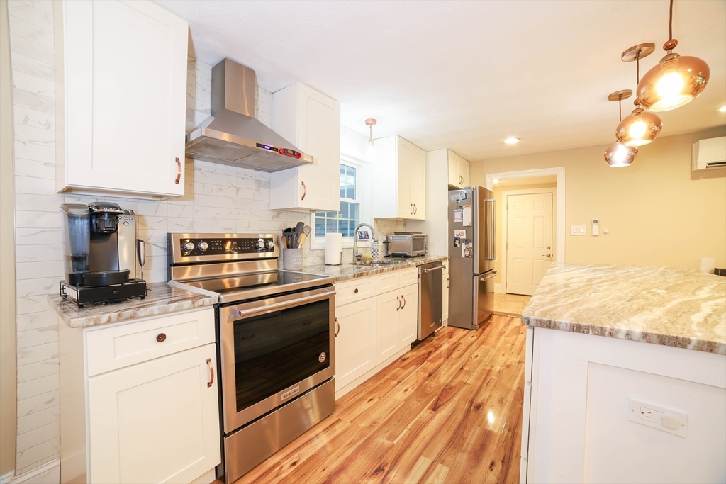 142 Mill Road Chelmsford, MA 01824 - Photo 3 of 34 a kitchen with stainless steel appliances granite countertop a sink a stove and cabinets