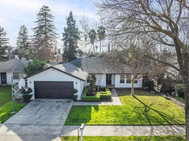 a view of a house with a yard patio and fire pit