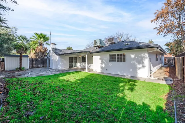 a view of a house with backyard and sitting area