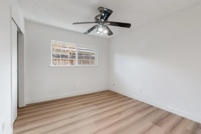 a view of empty room with wooden floor