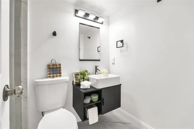 a bathroom with a toilet sink and mirror