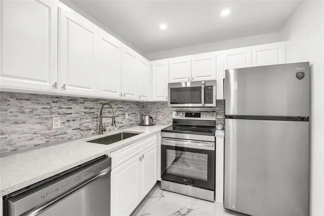 a kitchen with a sink stainless steel appliances and cabinets