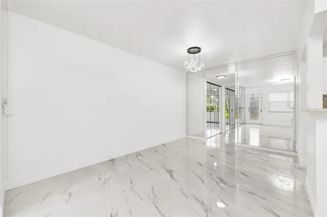 an empty room with wooden floor and a glass door shower