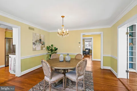 a view of a house with a small yard and a large tree