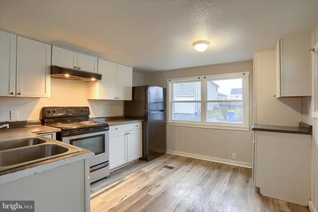 a kitchen with a stove a sink and a refrigerator