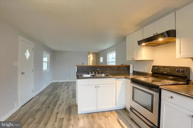 a kitchen with granite countertop a stove and a sink