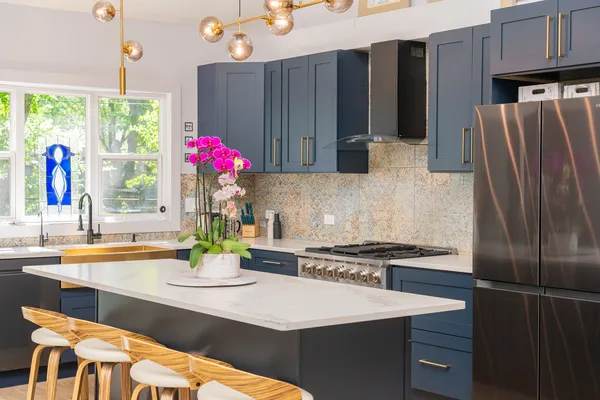 a kitchen with stainless steel appliances granite countertop a refrigerator and a stove