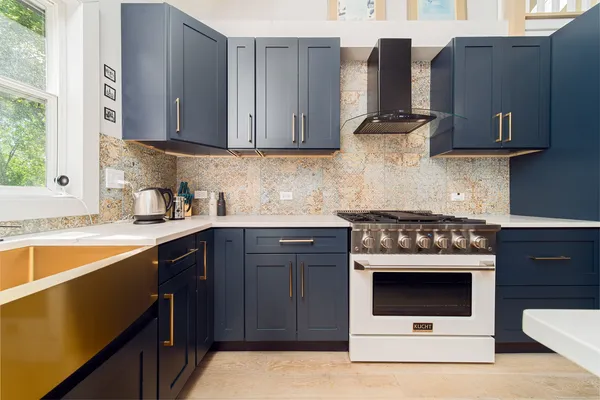 a kitchen with stainless steel appliances granite countertop a stove a sink and a microwave