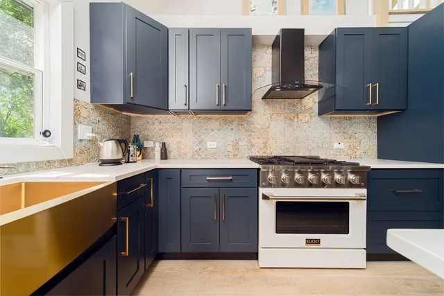 a kitchen with stainless steel appliances granite countertop a stove a sink and a microwave