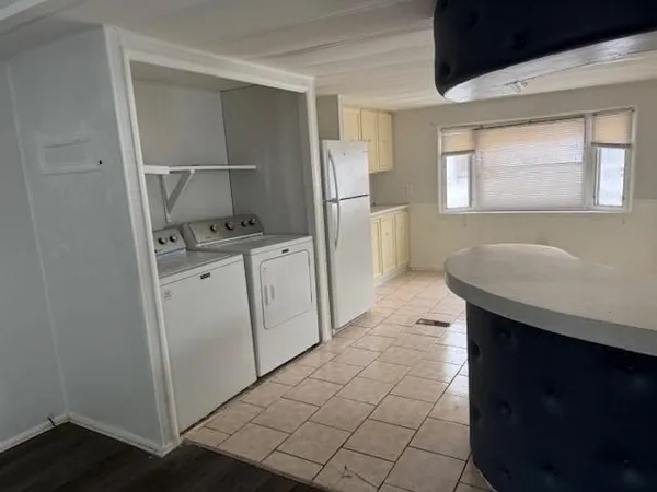 a kitchen with a sink a refrigerator and cabinets