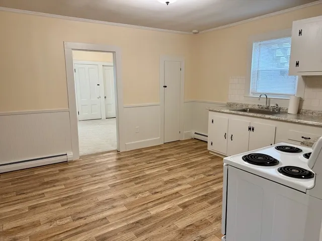 a kitchen with granite countertop white cabinets and white appliances