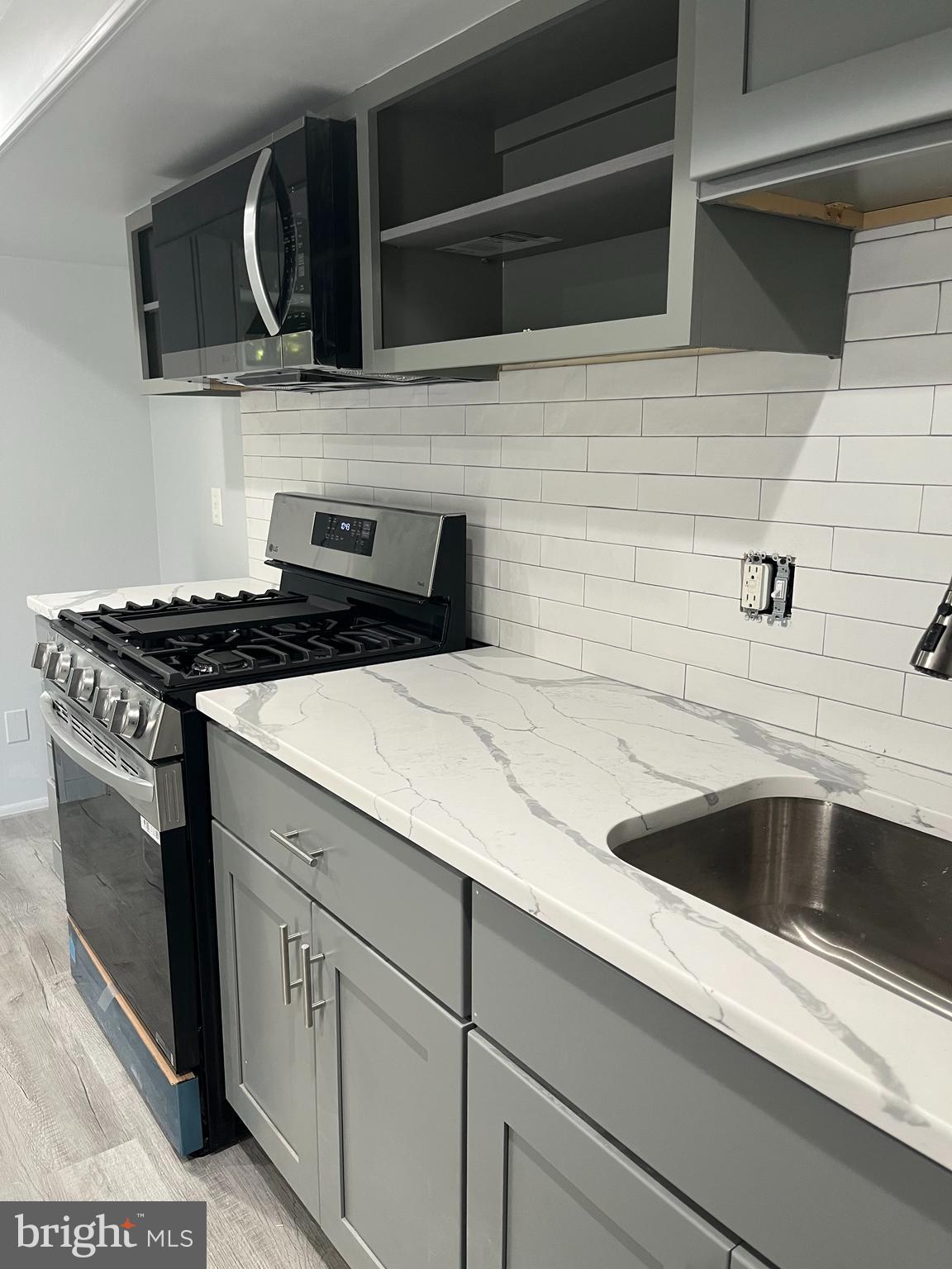a kitchen with granite countertop stainless steel appliances a sink and cabinets
