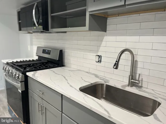 a kitchen with granite countertop a sink and a stove top oven