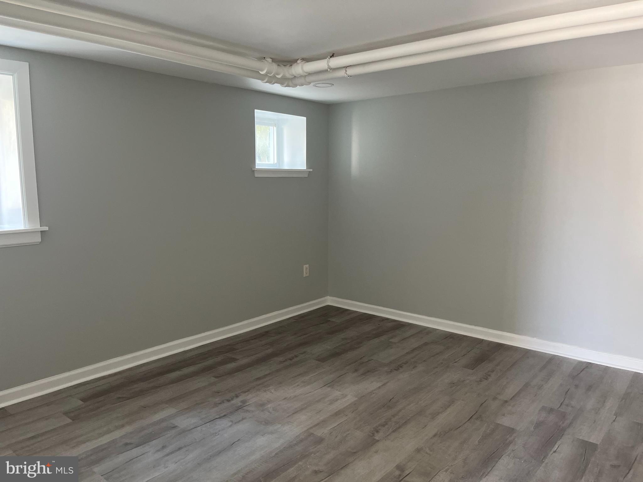 221 Conestoga Road, Unit 100 Wayne, PA 19087 - Photo 6 of 8 an empty room with wooden floor and windows