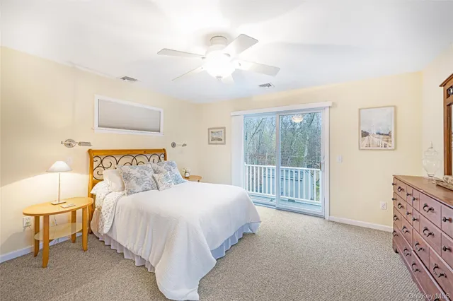 a bedroom with two beds chandelier and a window