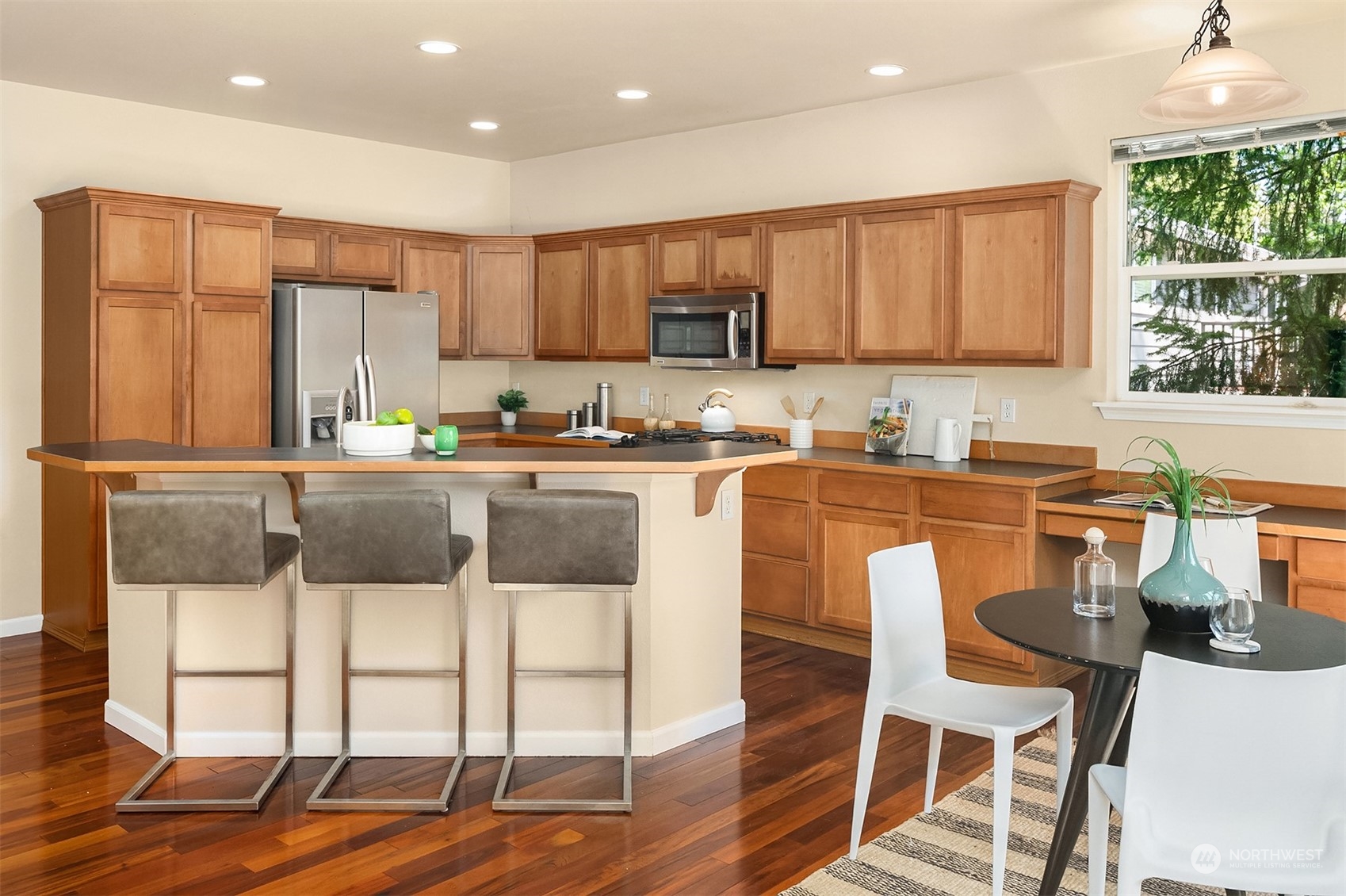 2017 Northeast 27th Street Renton, WA 98056 - Photo 8 of 27 a kitchen with stainless steel appliances granite countertop a stove a sink a microwave a dining table and chairs