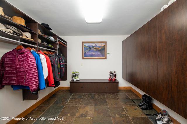 a view of walk in closet with clothes and shoes