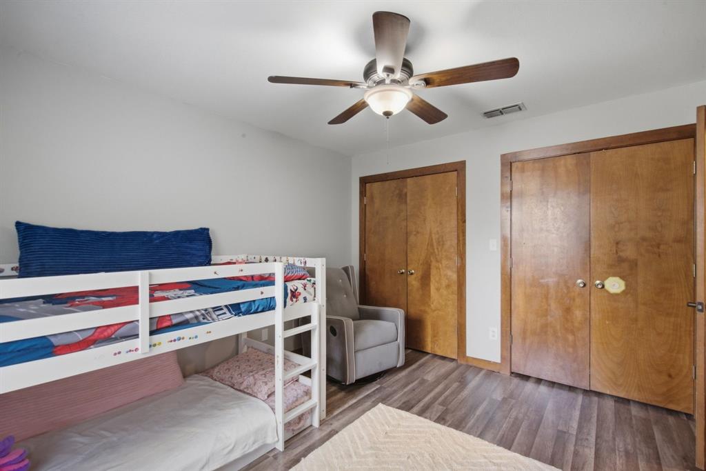 950 Johnson Bend Road Weatherford, TX 76088 - Photo 26 of 40 Wood-finish flooring, two wood bi-fold closet doors, ceiling fan with integrated lighting, and neutral wall paint