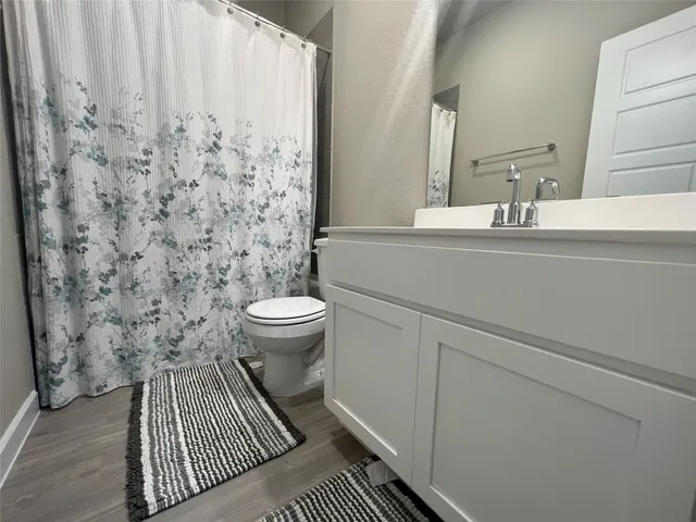 a bathroom with a sink a toilet and a mirror