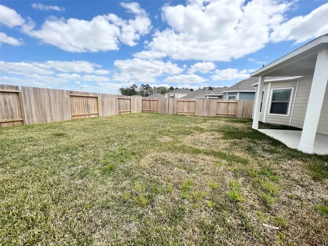 a view of a backyard with plants and wooden fence