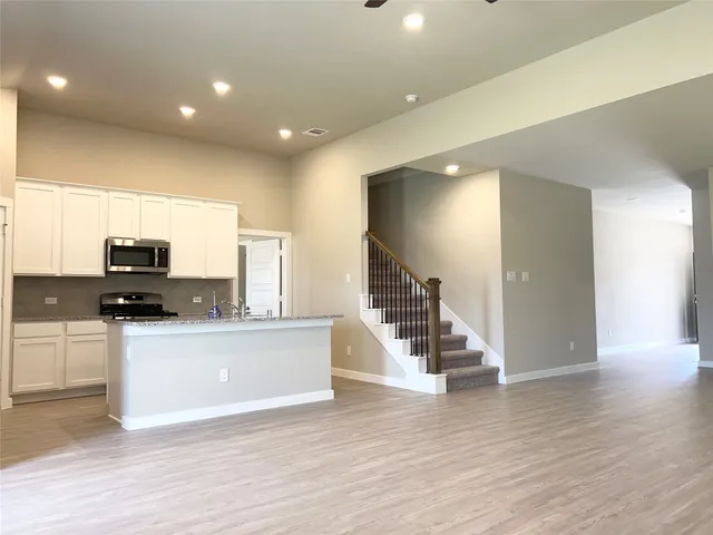 a view of kitchen with stainless steel appliances wooden floor and outdoor view