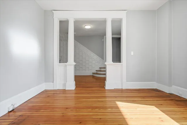 a view of a hallway with wooden floor and staircase