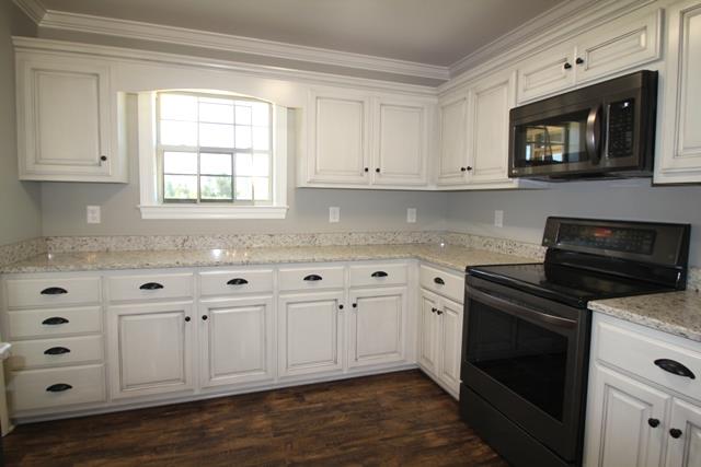 502 Taylor Road Manchester, TN 37355 - Photo 4 of 14 a kitchen with white cabinets and black appliances