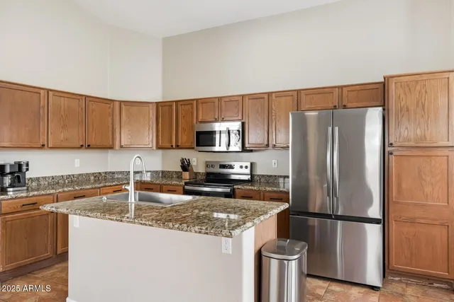 a dining hall with stainless steel appliances granite countertop a sink and a large window