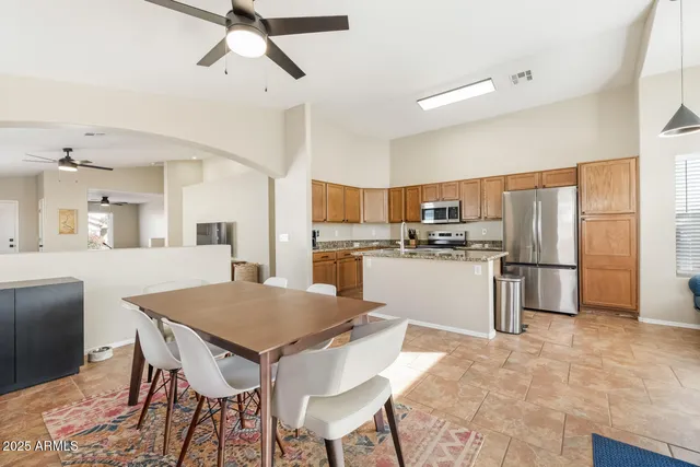 a open kitchen with granite countertop a table chairs sink and cabinets