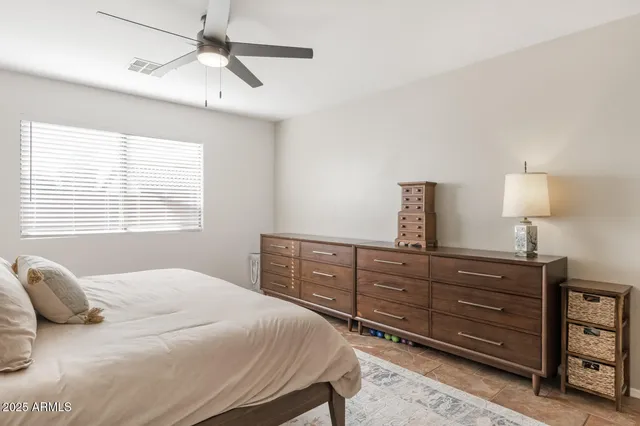 a bedroom with a bed and a ceiling fan