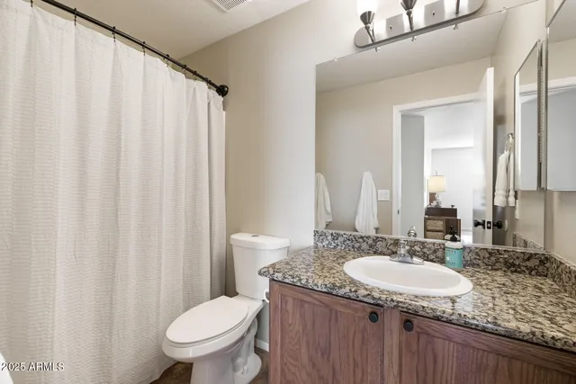 a bedroom with a bed and a painting on the wall