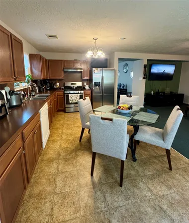 a living room with furniture a flat screen tv and kitchen view