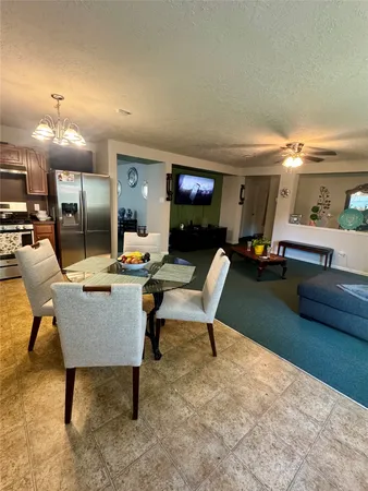 a living room with furniture a flat screen tv and a table
