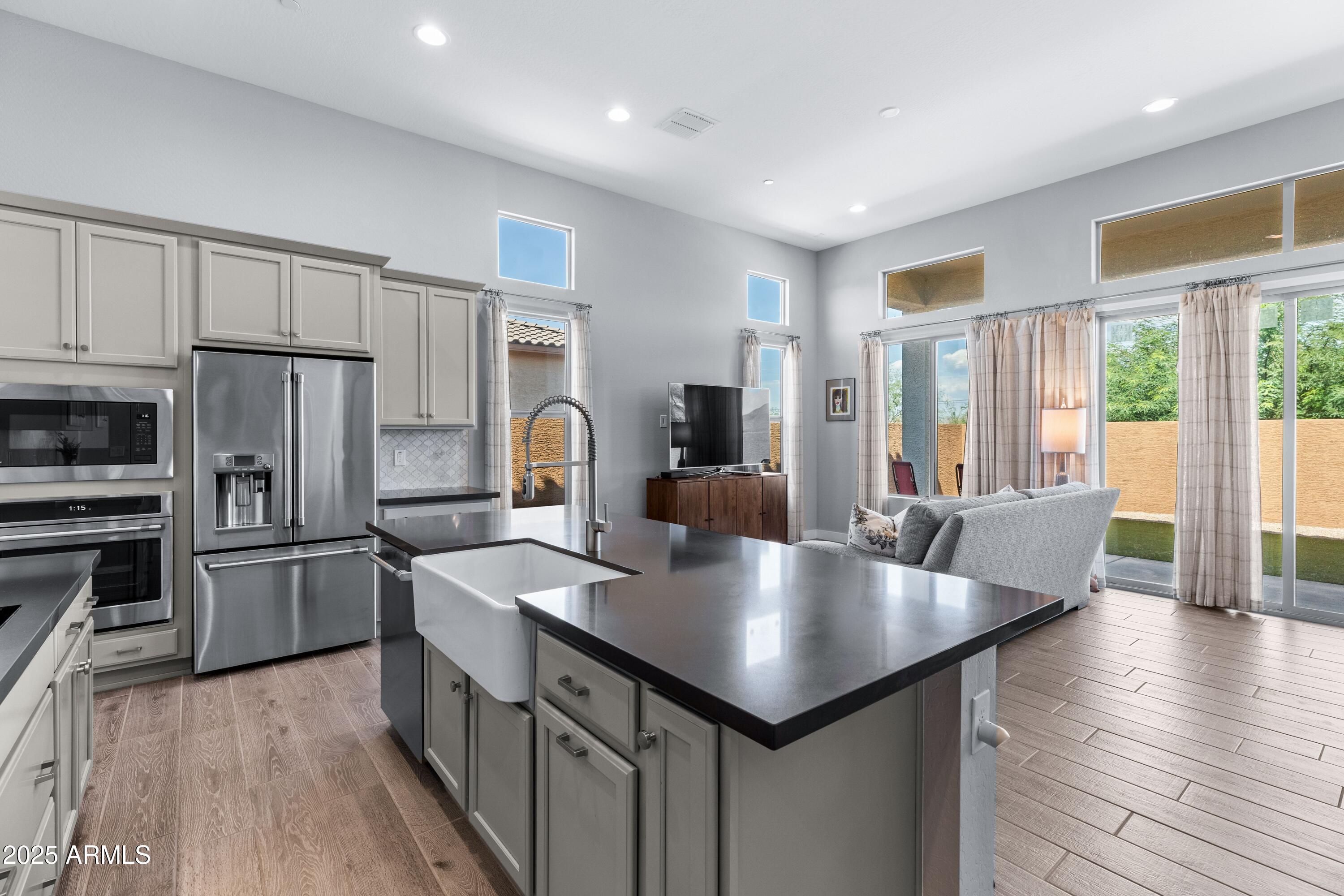 a large kitchen with kitchen island a large counter top space a sink stainless steel appliances and cabinets