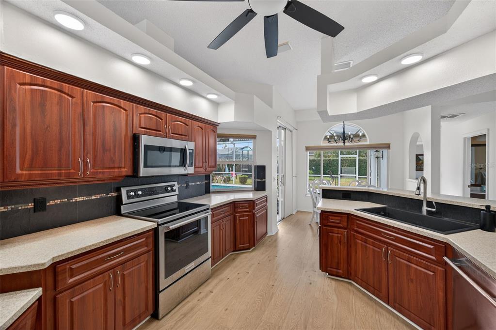 14178 Pullman Drive Spring Hill, FL 34609 - Photo 16 of 46 a kitchen with stainless steel appliances wooden cabinets and a stove top oven