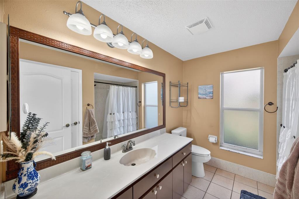 14178 Pullman Drive Spring Hill, FL 34609 - Photo 26 of 46 a bathroom with a sink vanity granite toilet and shower