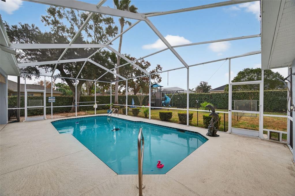 14178 Pullman Drive Spring Hill, FL 34609 - Photo 32 of 46 a view of a swimming pool with a yard and lawn chairs