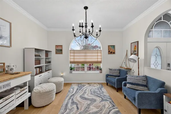 a living room with furniture chandelier and a window