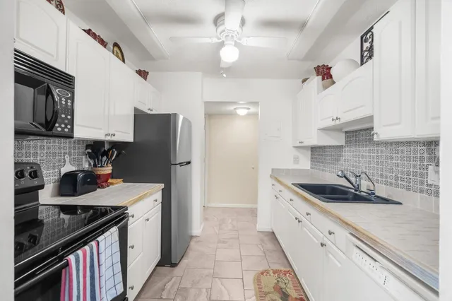 a kitchen with a sink stove top oven and refrigerator