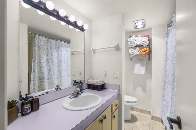 a bathroom with a sink a toilet and a mirror