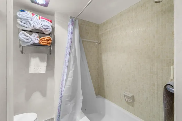 a bathroom with a sink a toilet and shower curtain