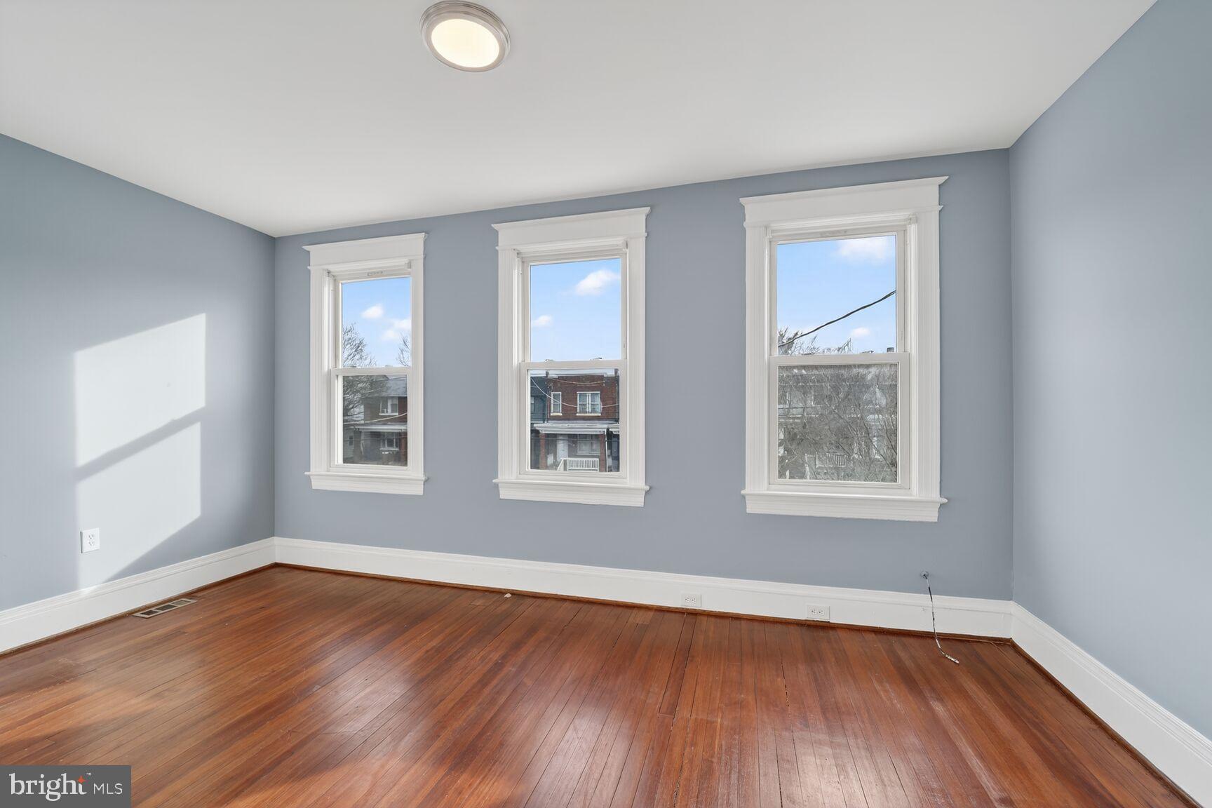 632 Franklin Street Northeast Washington, DC 20017 - Photo 6 of 19 an empty room with wooden floor and windows